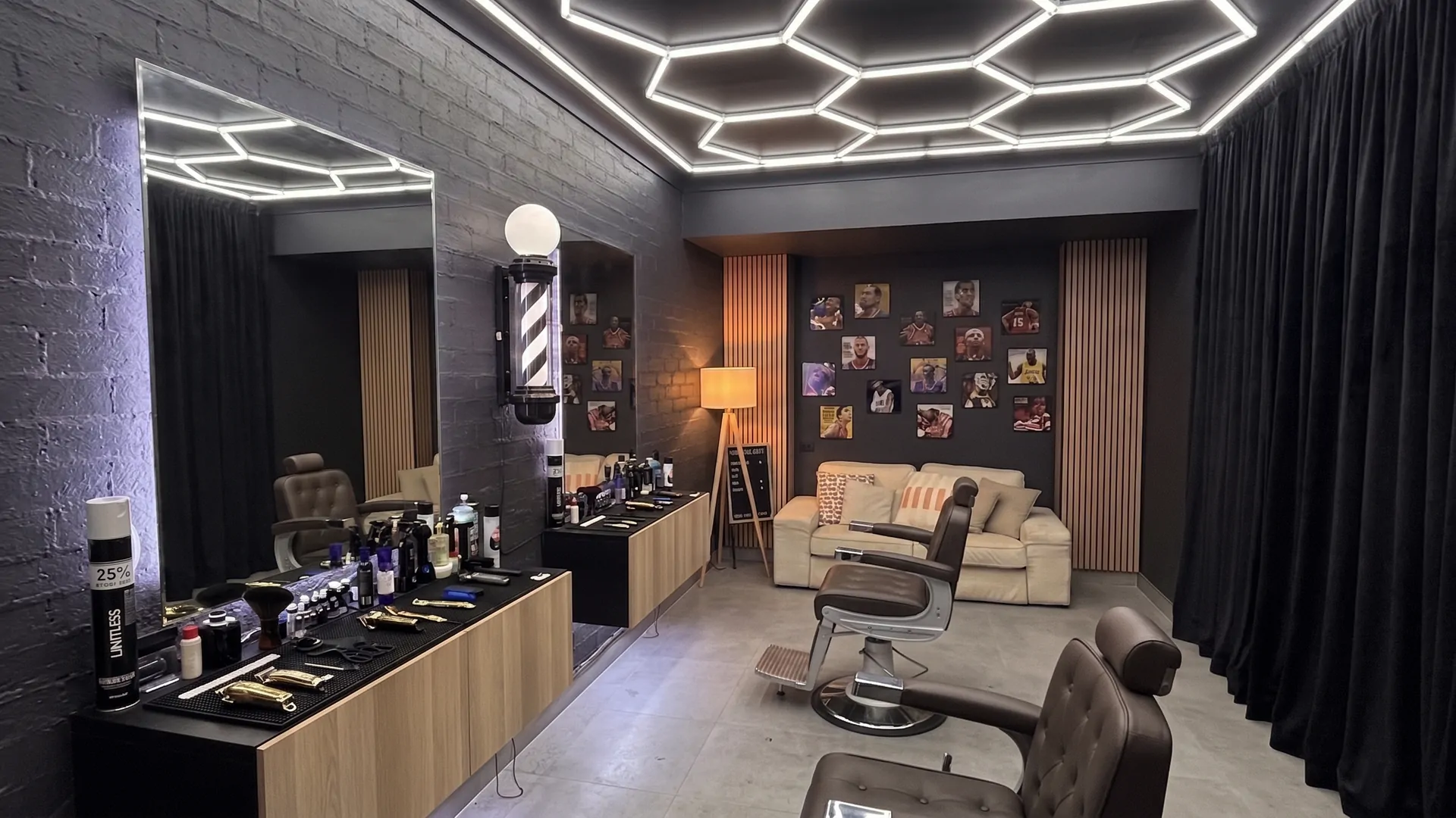 Inside the Clipper Culture studio — hexagon LED ceiling, dual barber chairs, and the lounge wall